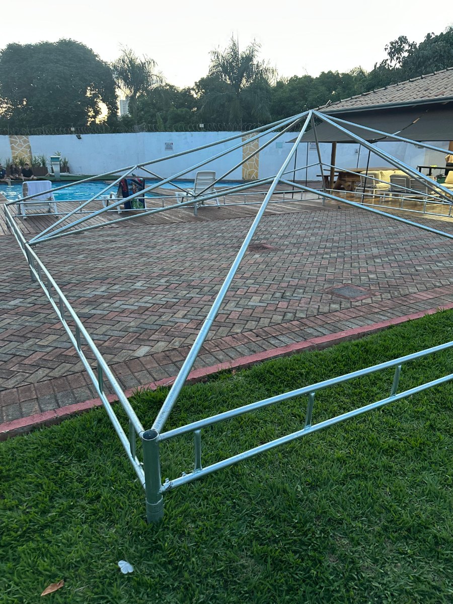 Estrutura de aço galvanizado da tenda piramidal montada sobre a grama, antes de receber a lona