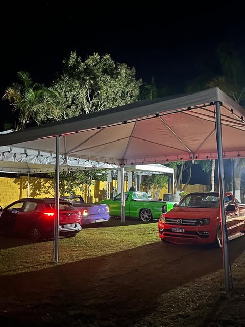 Tendas iluminadas cobrindo carros à noite
