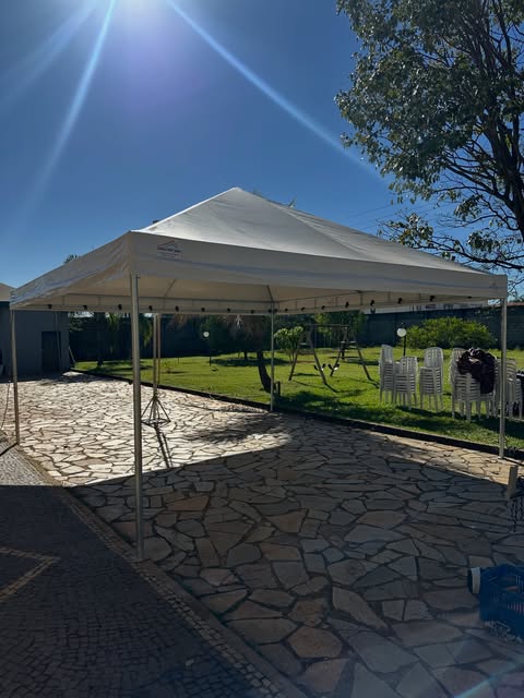 Tenda piramidal em pátio de pedra com céu azul