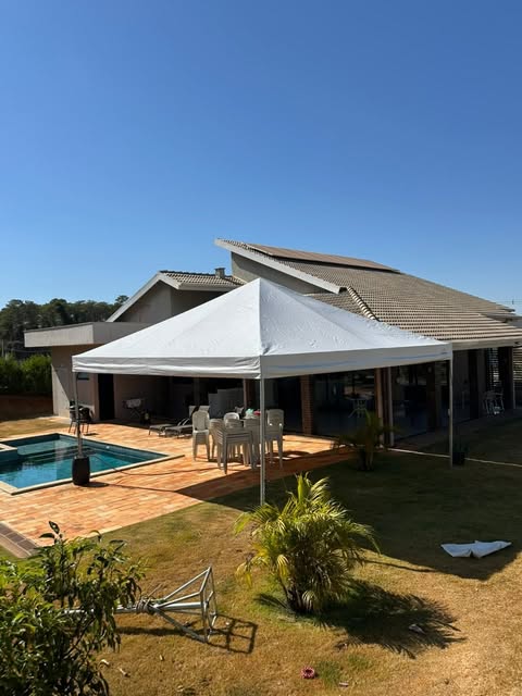 Tenda branca ao lado de piscina em residência